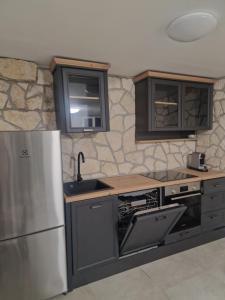 a kitchen with a stainless steel refrigerator and a sink at Apartments Jelinek in Brela