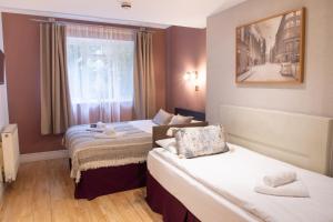 a hotel room with two beds and a window at 72QT in London