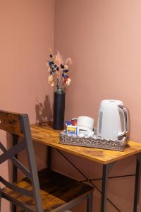 a table with a coffee maker and a toaster and flowers at 72QT in London