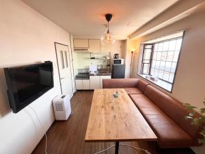 a living room with a couch and a wooden table at High-speed Wi-Fi Station front Kamishinjo in Osaka