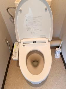 a toilet with the lid up in a bathroom at High-speed Wi-Fi Station front Kamishinjo in Osaka +24 photos