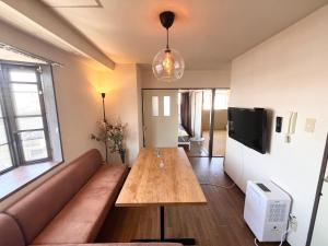 a living room with a couch and a wooden table at High-speed Wi-Fi Station front Kamishinjo in Osaka