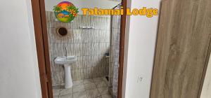a bathroom with a toilet and a sink at Tatamai Lodge in Nuku Hiva