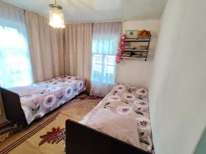 a bedroom with two beds and a window at Arslanbob guest house Mamajanov in Arslanbob