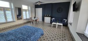 a bedroom with a blue bed and a table at Gite La Ferme du Château in Cerfontaine