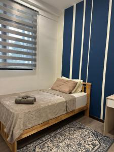 a bedroom with a bed and a blue wall at ANTARA Muji Serenity Condo in Putrajaya +14 photos