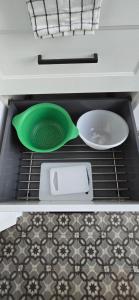 a green strainer and two plates in an oven at Gite La Ferme du Château in Cerfontaine +12 photos