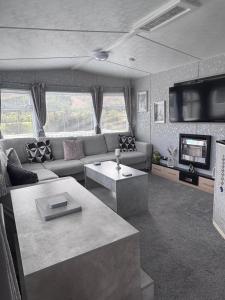 a living room with a couch and a tv at Blairgowrie in Ballintuim