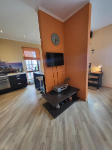 a living room with a tv on a wall at SolarisStudioApartments near the Airport in Riga