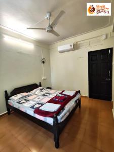 a bed in a room with a ceiling fan at Hotel Shahi Residency in Panhāla