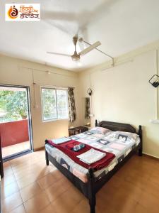 a bedroom with a bed and a ceiling fan at Hotel Shahi Residency in Panhāla