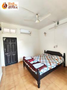 a bedroom with a bed and a black door at Hotel Shahi Residency in Panhāla