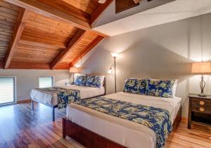 two beds in a room with wooden ceilings at Kihei Resort 202 · KRS 202 Family Getaway 2BD w AC Pool Beach in Kihei +37 photos