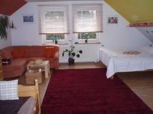 een woonkamer met een bank, een bed en ramen bij Apartmán Pod lesem in Lipova Lazne