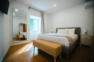 a bedroom with a large bed and a mirror at Casa do Mar in Ribeira Grande