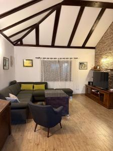 a living room with a couch and a tv at House on the river in Karlovac