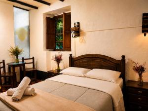 a bedroom with two beds and a window at Hotel Pueblo Dorado Sesquilé in Sesquilé