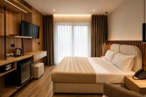 a hotel room with a bed and a television at Albatros Beach & Resort in Rrogozhinë