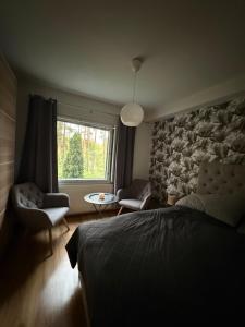a bedroom with a bed and a window and a chair at LIS Apartment in Naantali