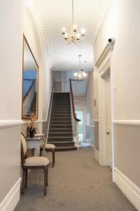 a hallway with stairs and a chandelier at 72QT in London +36 photos