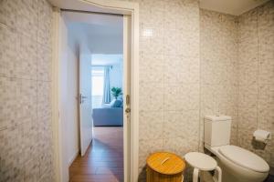 a bathroom with a toilet and a wooden table at Casa do Mar in Ribeira Grande +126 photos