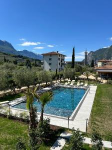 a swimming pool with chairs and a building in the background at Casa Maria Apartments in Riva del Garda