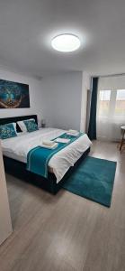 a bedroom with a large bed with a blue rug at Mady STUDIO in Hunedoara