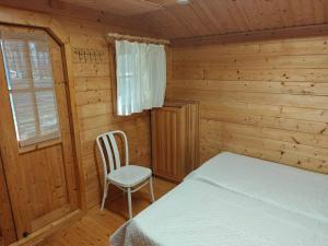 a bedroom with a bed and a chair in a cabin at Mere in Yarve-Keskranna