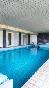 a large swimming pool with blue tiles in a building at Isabell in Schönwald