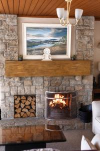 a living room with a stone fireplace with a painting at Killarney View House B&B in Killarney