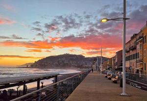 a street light next to a beach at sunset at sunset suite con terrazza e barbecue in Imperia +8 photos