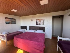 a bedroom with two beds and a wooden ceiling at Pousada nas Montanhas Recanto Querubins in Paty do Alferes +142 photos