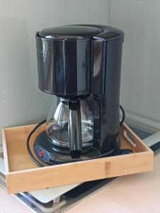 a black coffee maker sitting on a wooden shelf at Ferienwohnung Diepold in Wasserburg