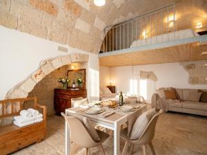 a living room with a table and chairs and a couch at Casa Tino - Retreat by the Sea and History in Polignano a Mare
