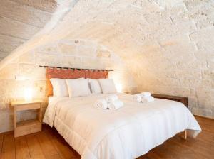 a bedroom with a bed with towels on it at Casa Tino - Retreat by the Sea and History in Polignano a Mare