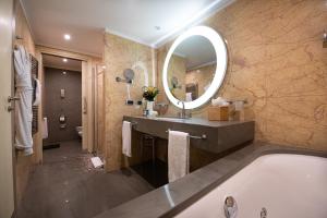 a bathroom with a tub and a large mirror at Port Palace in Monte Carlo
