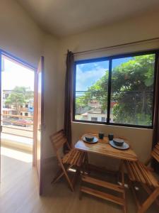 a table and chairs in a room with a large window at Tayta Huasy in Montañita