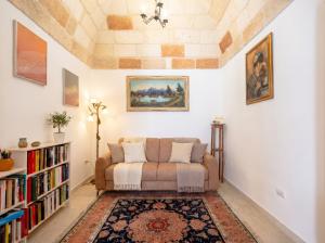 a living room with a couch and a book shelf at Casa Tino Panorama Skyline in Polignano a Mare
