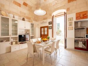 a kitchen with a white table and chairs at Casa Tino Panorama Skyline in Polignano a Mare