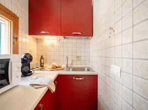 a small kitchen with red cabinets and a sink at Casa Tino Panorama Skyline in Polignano a Mare +13 photos