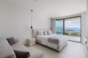 a white bedroom with a bed and a large window at Villa Eleni Di Mare in Kontokali +16 photos