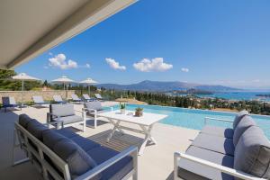 a patio with chairs and a table and a pool at Villa Eleni Di Mare in Kontokali