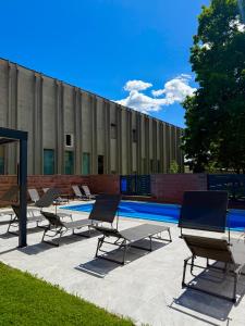 a group of chairs sitting next to a swimming pool at Villa Moste Ljubljana - Modern apartments with Pool, EV station & free parking in Ljubljana