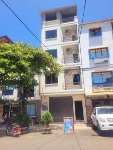 a tall white building with a sign in front of it at Tayta Huasy in Montañita
