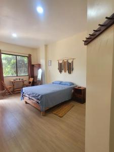 a bedroom with a bed and a desk in it at Tayta Huasy in Montañita
