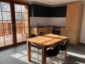 a kitchen with a wooden table and chairs at Sole Mountain apartement in Zermatt