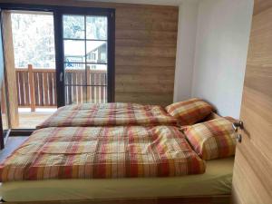 a bedroom with a bed and a large window at Sole Mountain apartement in Zermatt