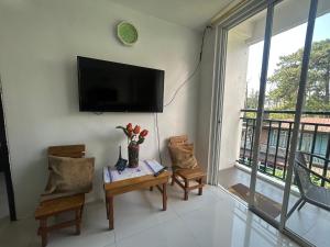 a living room with a tv and a table and chairs at 2BR Burnham Hill Condo for 8 -DOT Accredited in Baguio