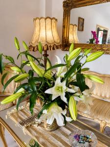 a vase of flowers on a table in front of a mirror at Pałacyk in Międzywodzie