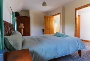 a bedroom with a large bed with blue sheets at Stonechat Cottage - Portmagee in Portmagee
